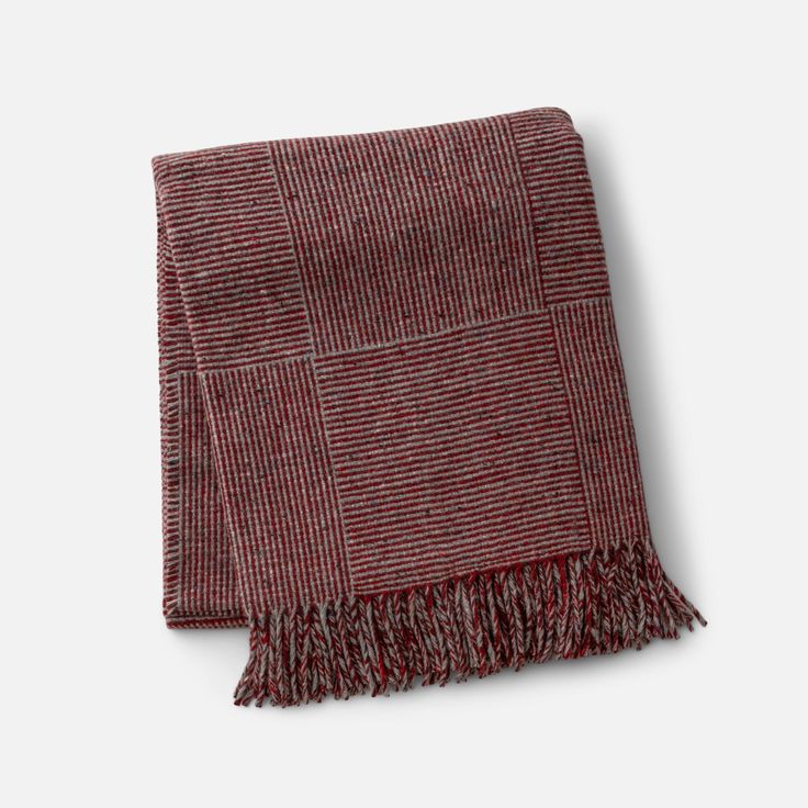 a red and grey blanket with fringes