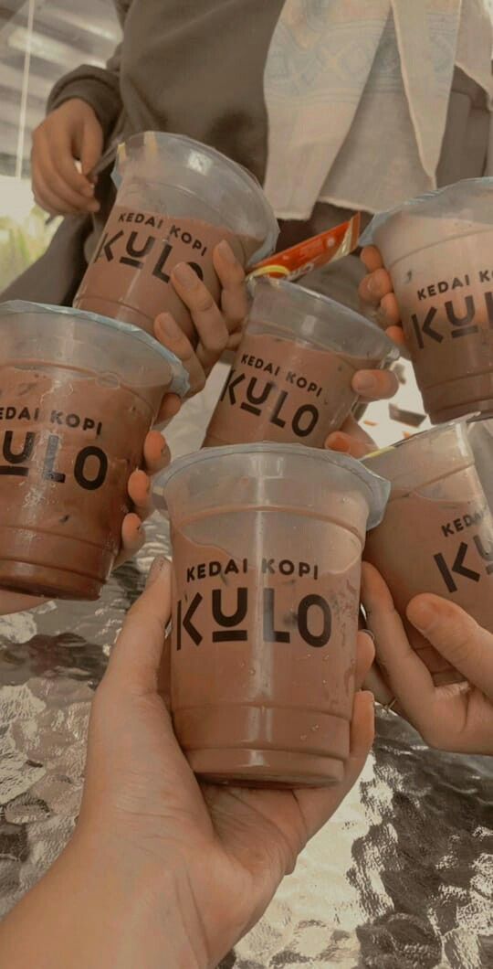 several people holding up cups with the word kulo written on them in different languages