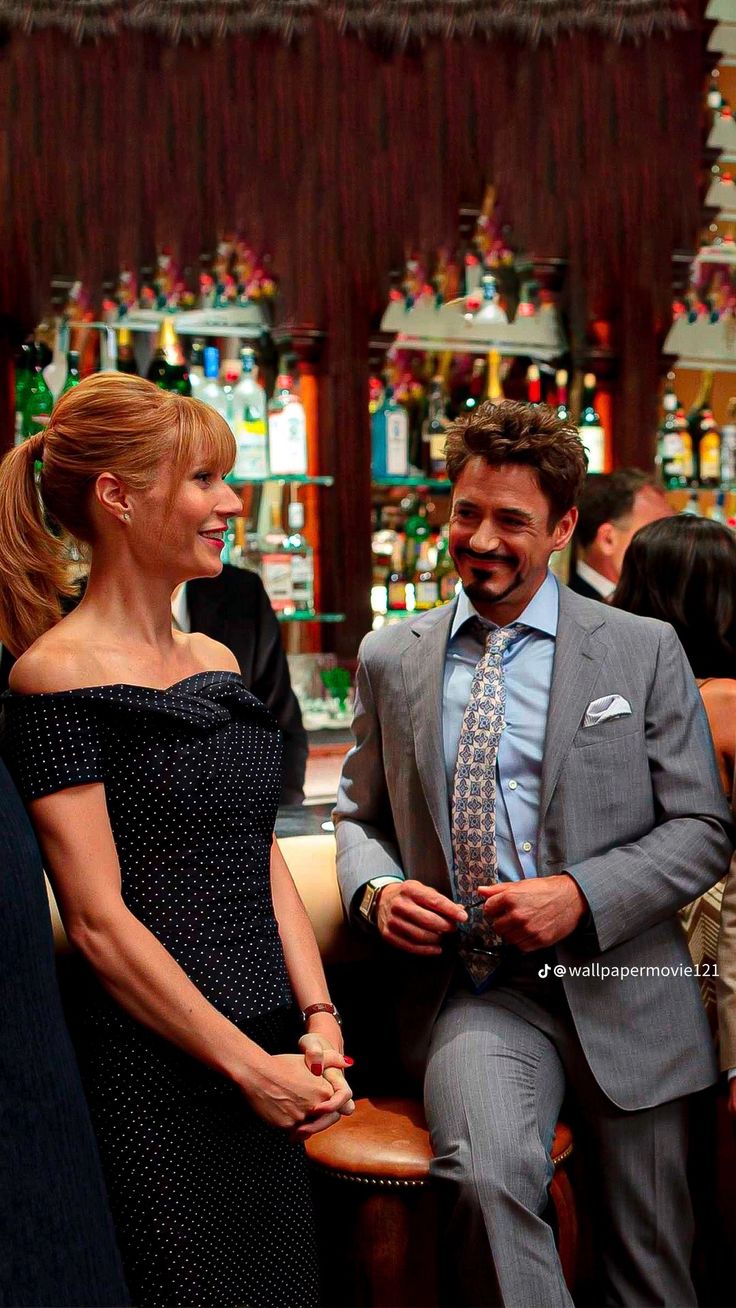 a man in a suit and tie sitting next to a woman