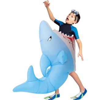 a young boy in a costume is riding a shark