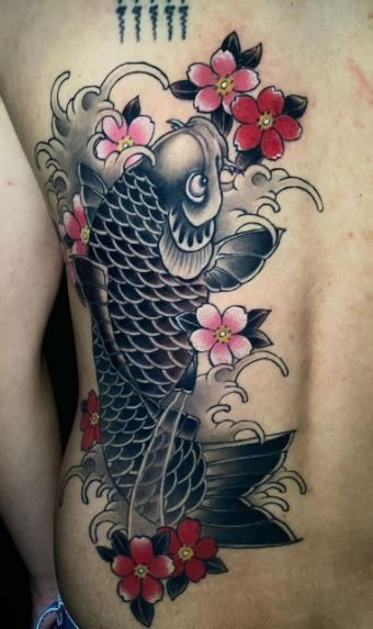 a man with a tattoo on his back is wearing a koi fish and flowers