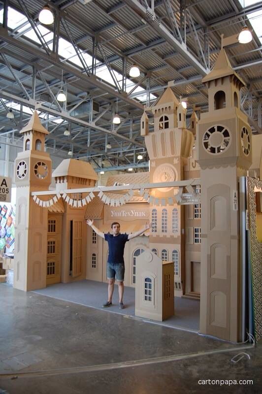 a man standing in front of a cardboard castle