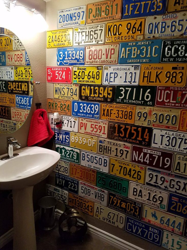 a bathroom with license plates on the wall and a white sink in front of it