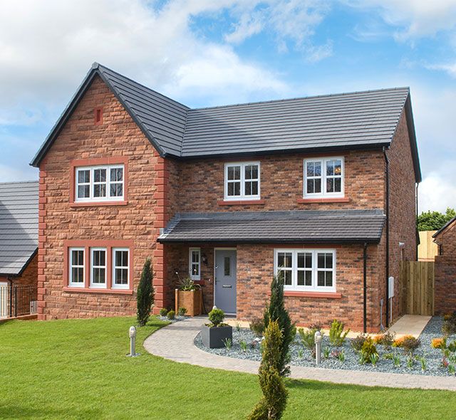 a large brick house sitting on top of a lush green field