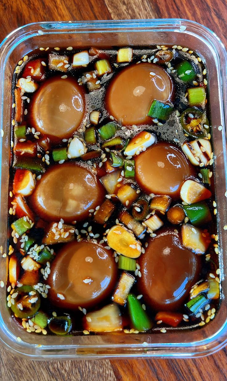 a glass dish filled with food on top of a wooden table