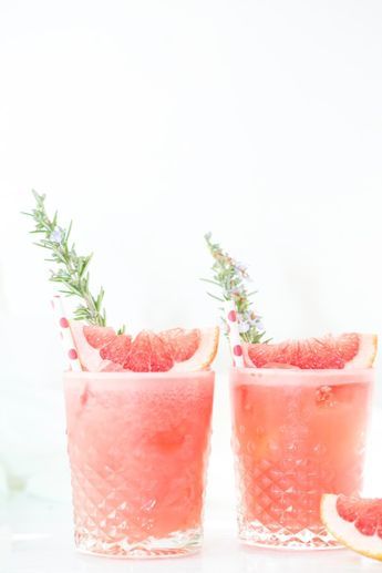 two grapefruit cocktails with rosemary garnish on the rim and one filled with watermelon