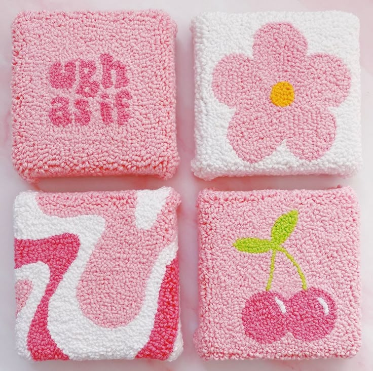 four pink coasters with flowers and cherries on them, one has the number seventy seven