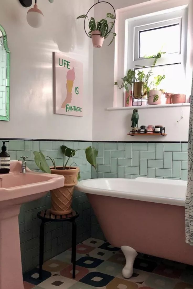 a pink bath tub sitting under a window next to a sink in a room with tiled floors