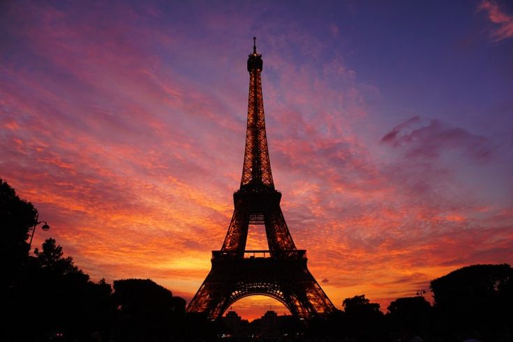 the eiffel tower is lit up at sunset