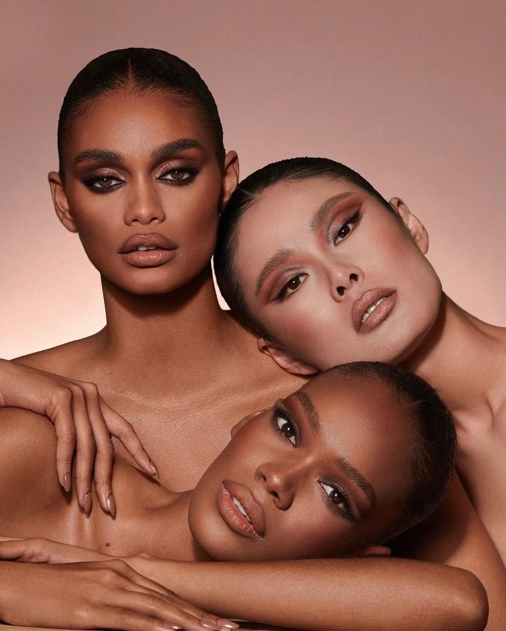 three nude women posing for the camera with their arms around each other and one woman's chest