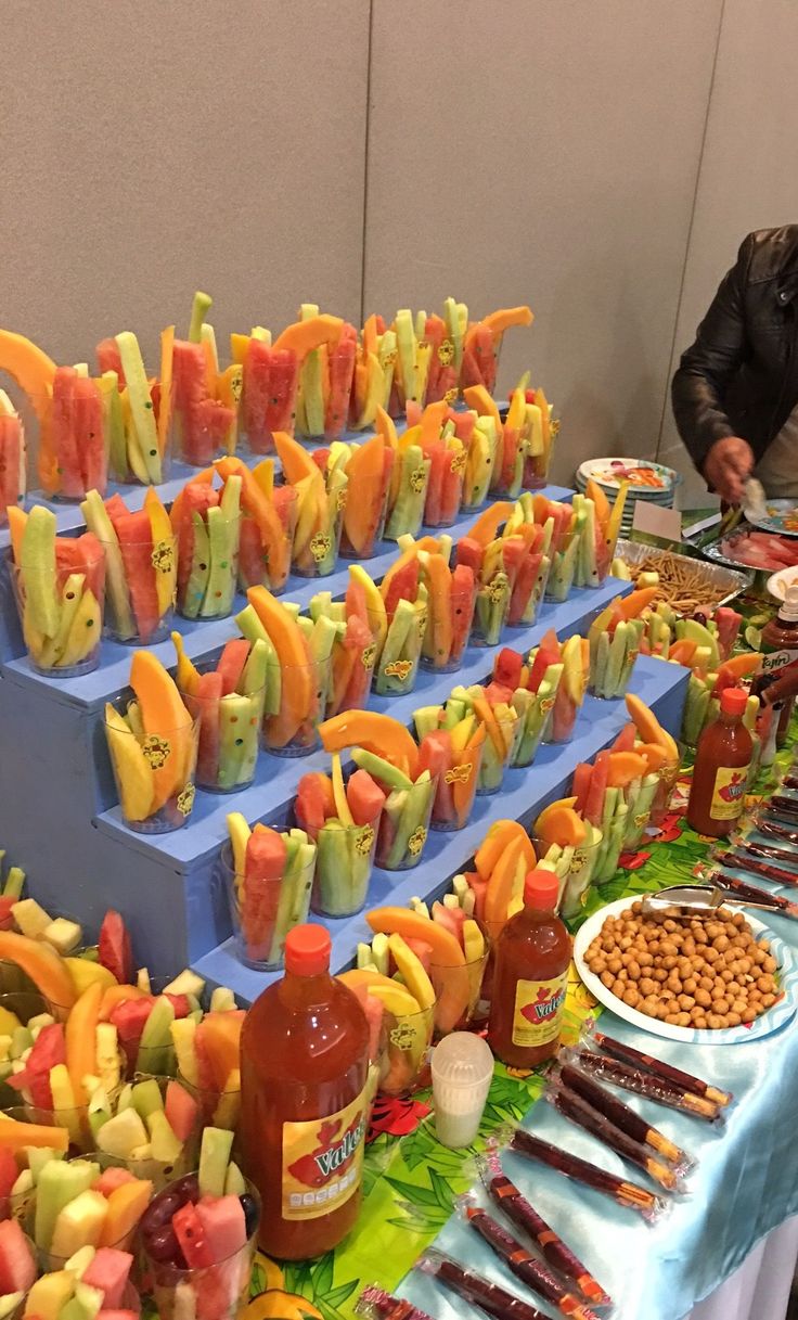 a buffet table filled with lots of different types of fruit and snacks on it's trays