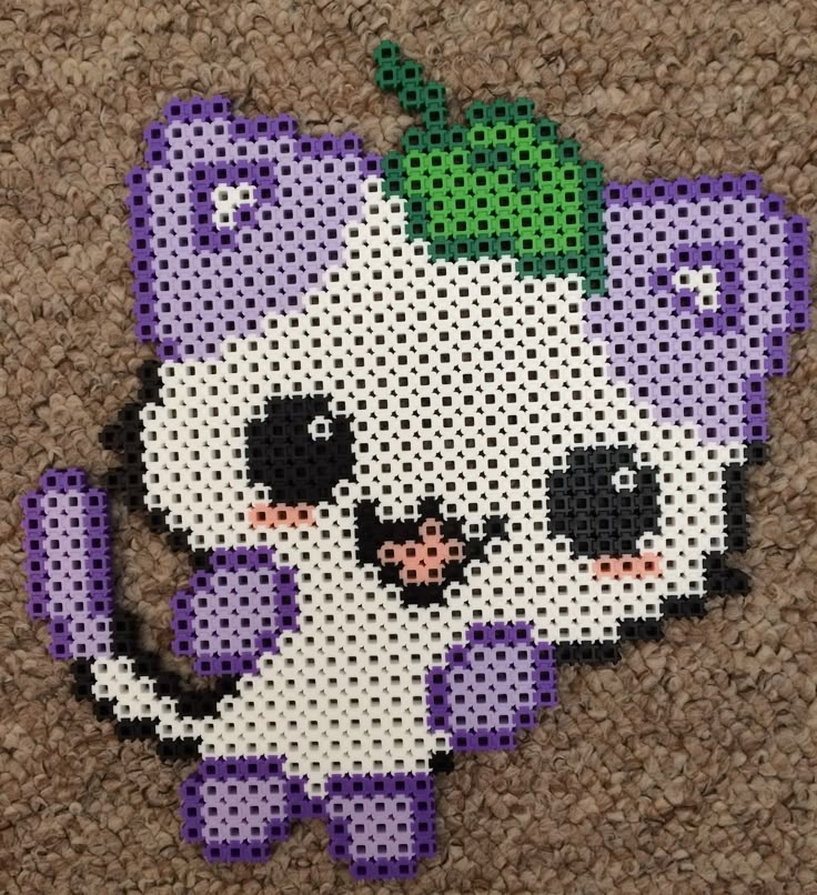 a cross stitch pattern of a purple and white cat with a green bow on it's head