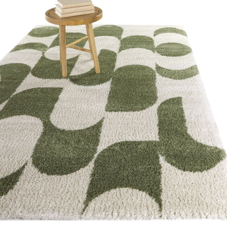 a green and white area rug with circles on the top, in front of a wooden chair