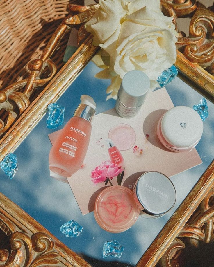 the beauty products are sitting on the table next to the flower and glass vases