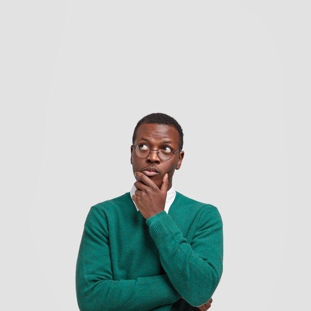 a man in a green sweater is looking at the camera with his hand on his chin