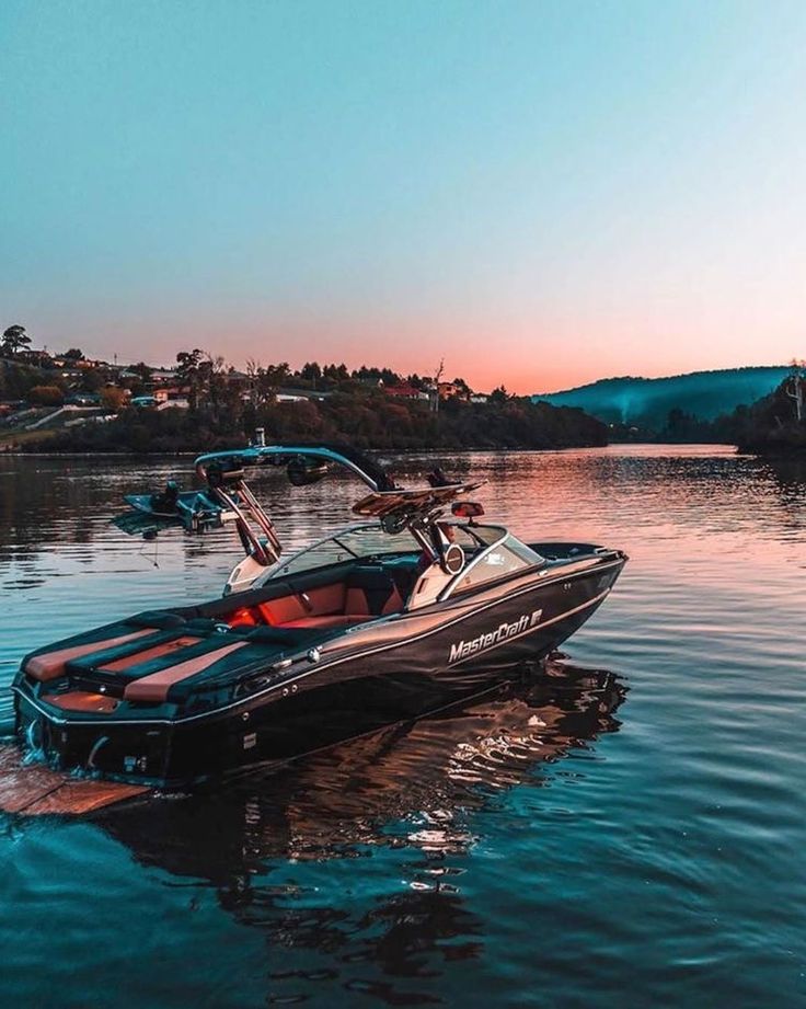 a speed boat in the water at sunset