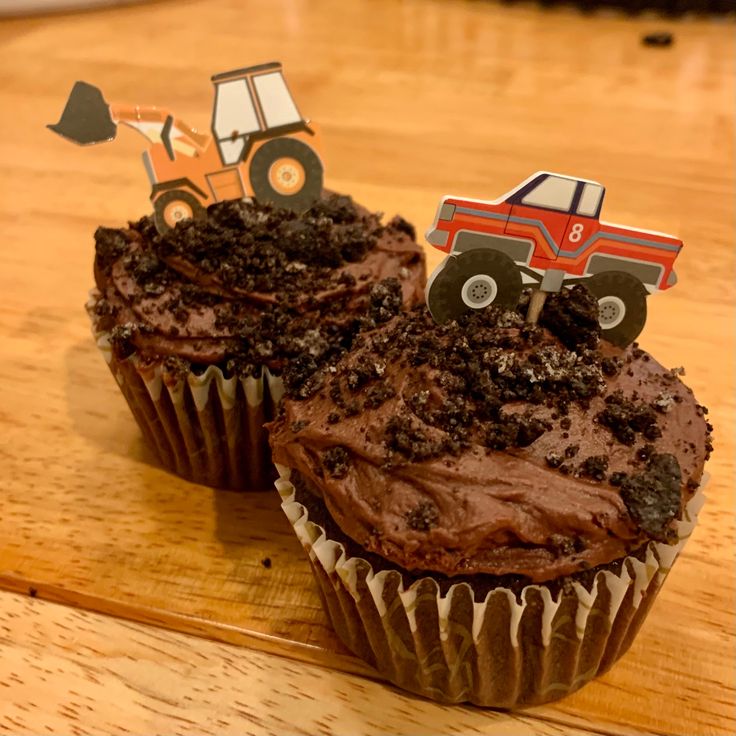 Two Chocolate cupcakes with crushed Oreo “dirt” and toothpick truck toppers. Cupcake Truck Ideas, Truck Birthday Cupcakes, Construction Birthday Party Cupcakes, Truck Themed Cupcakes, Car Themed Cupcakes, Dirt Cupcakes Construction, Monster Jam Cupcakes Ideas, Monster Truck Pull Apart Cupcakes, Monster Jam Cupcake Cake