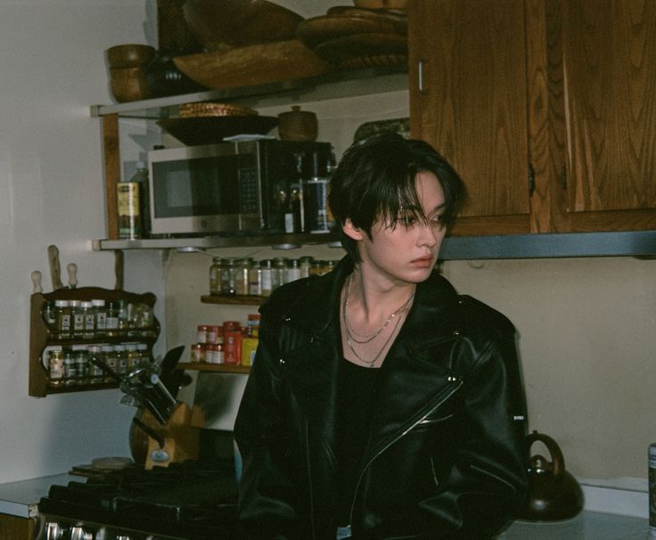 a woman standing in a kitchen next to a stove top oven