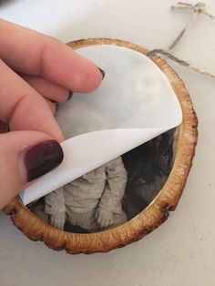 a person is using a knife to cut through the wood slice with their fingernails