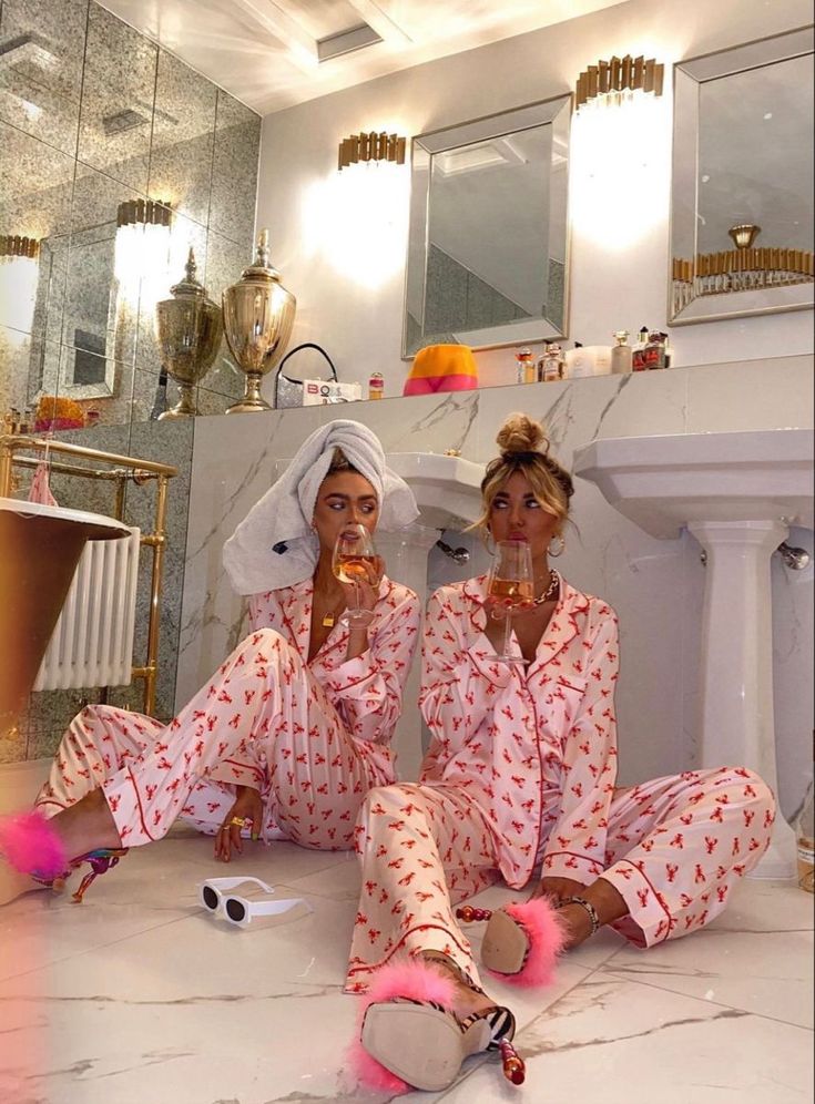 two women sitting on the floor in matching pajamas