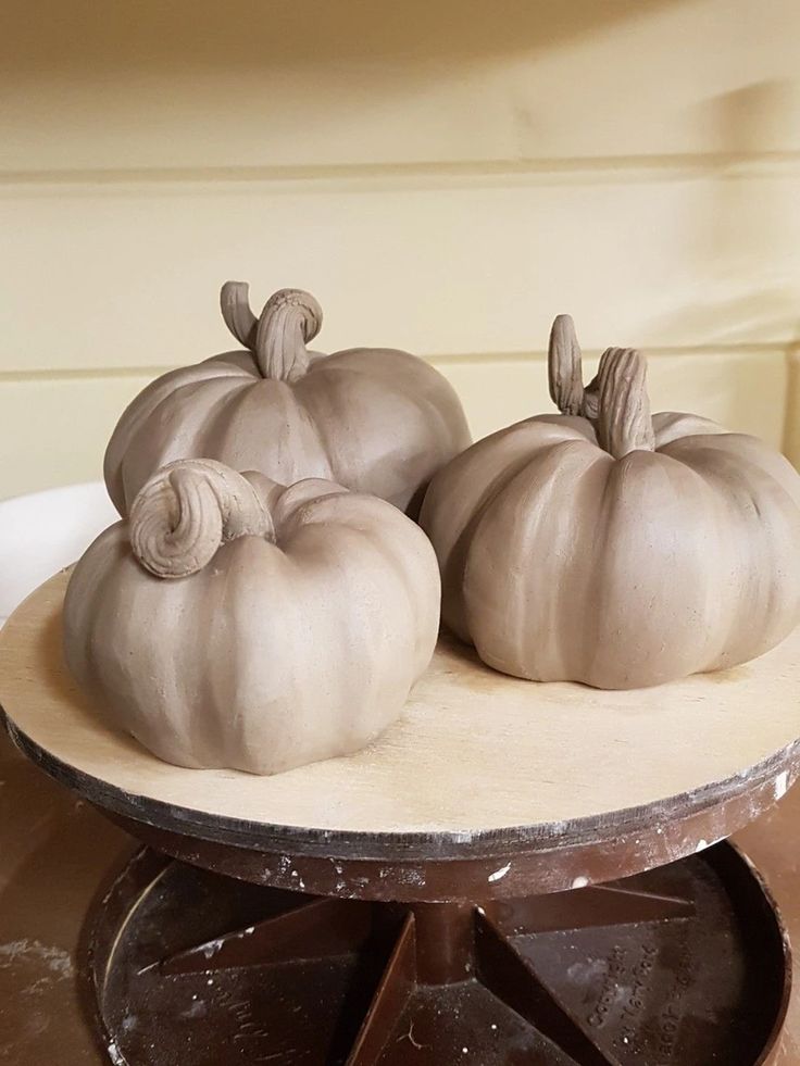 three white pumpkins sitting on top of a table