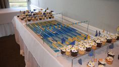 a table topped with lots of cupcakes covered in frosting