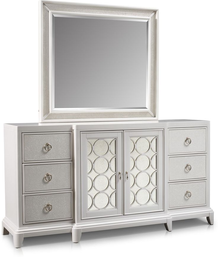 a white dresser with a mirror on top and drawers below it, in front of a white background