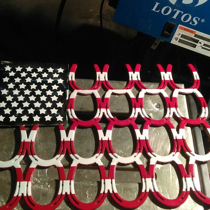 red and white scissors sitting next to each other on top of a metal table with an american flag in the background