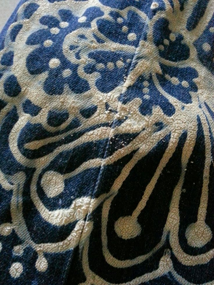 a blue and white towel with an intricate design on the bottom, sitting on top of a table