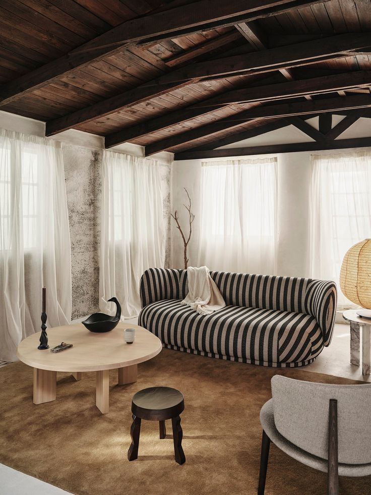 a living room with striped couches and round coffee table in it's center