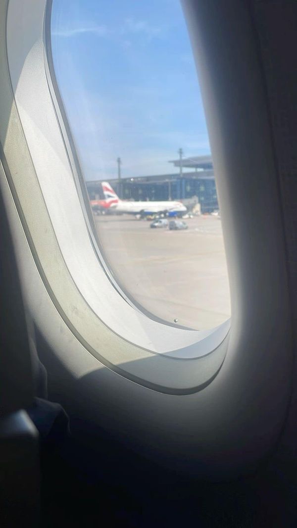 an airplane window looking out at airplanes on the tarmac