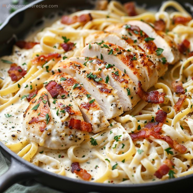 chicken and bacon pasta in a skillet with parmesan cheese sauce on the side