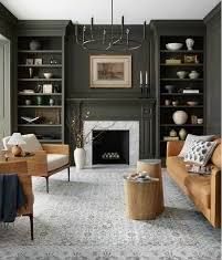 a living room filled with furniture and a fire place under a chandelier in front of a fireplace