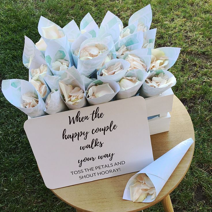 a bouquet of flowers sitting on top of a table next to a sign that says, where the happy couple smiles your way