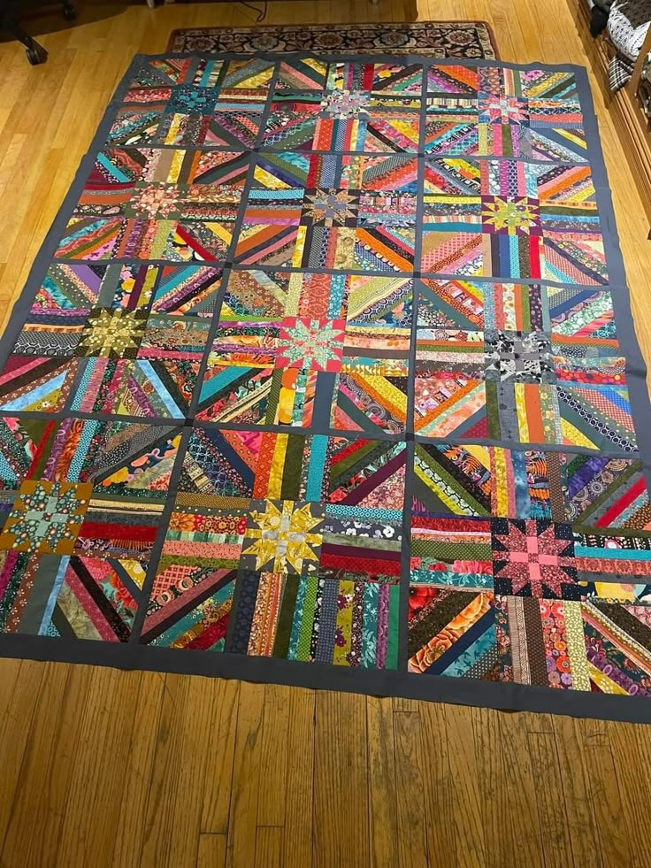 a large quilt is laying on the floor