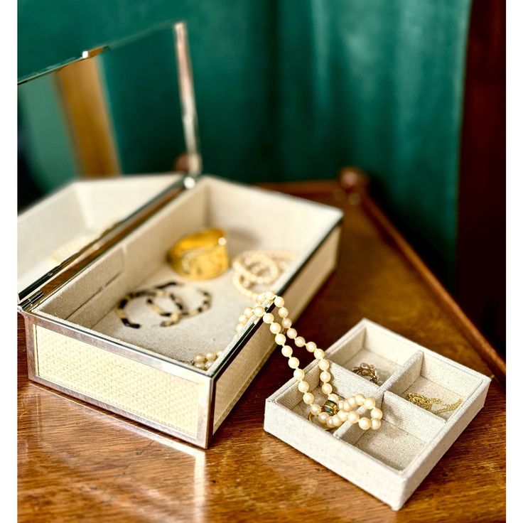 an open jewelry box sitting on top of a wooden table