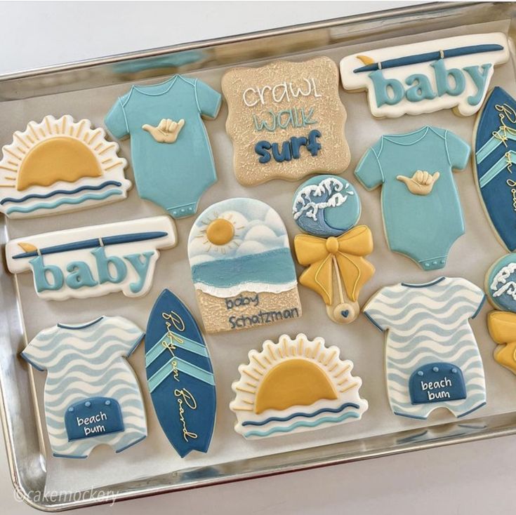 baby shower cookies in a clear box with blue and yellow onesuits on them