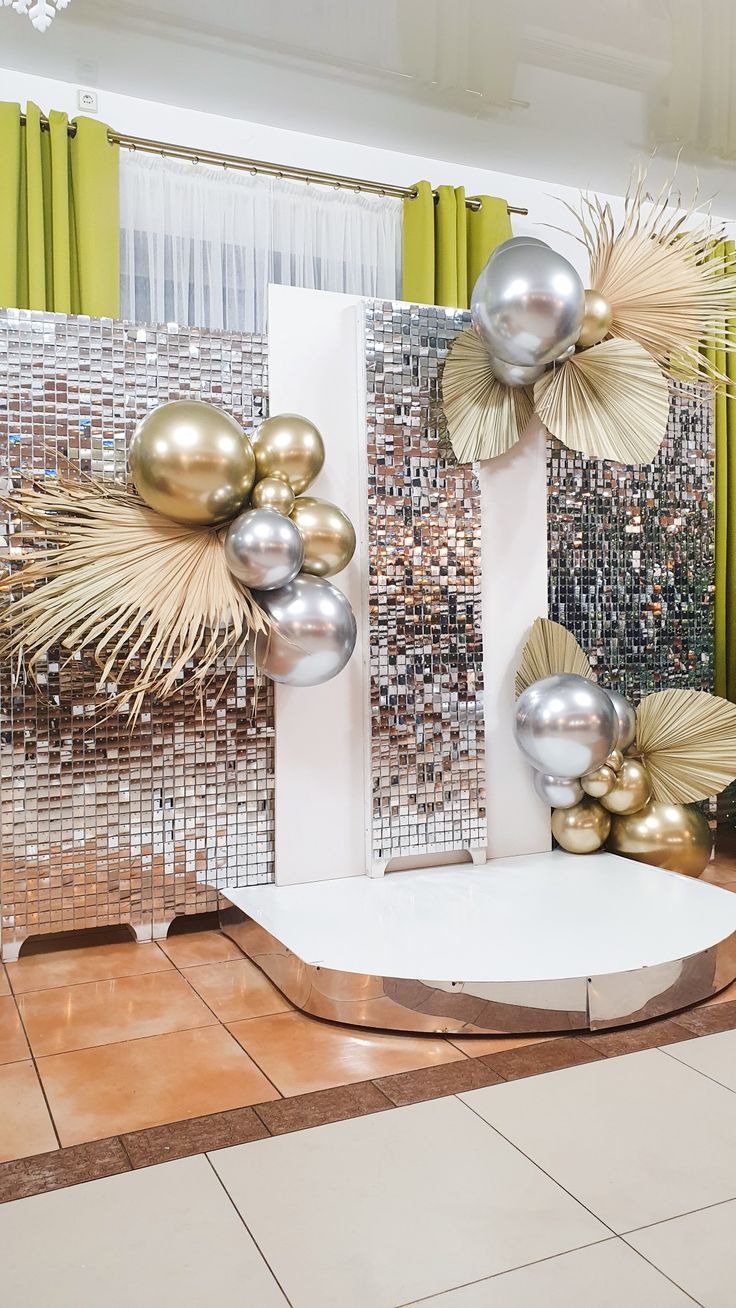 a room filled with lots of shiny balloons and decorations on the wall behind it,