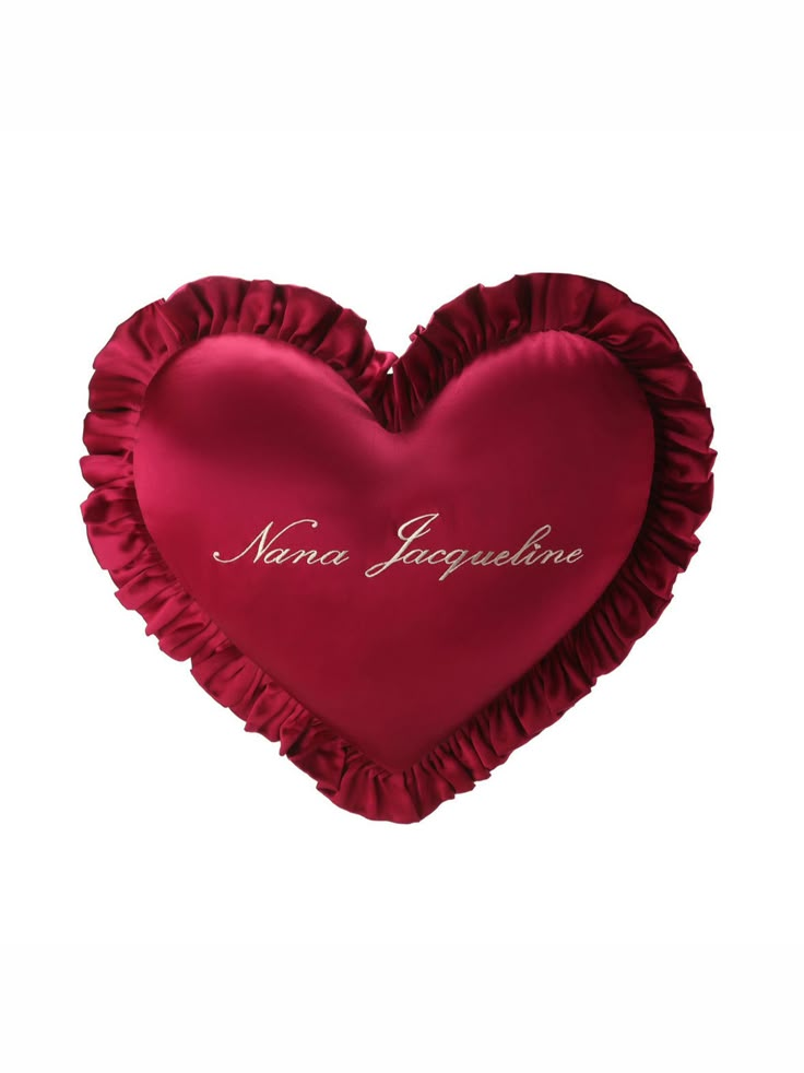 a red heart shaped pillow with name on it