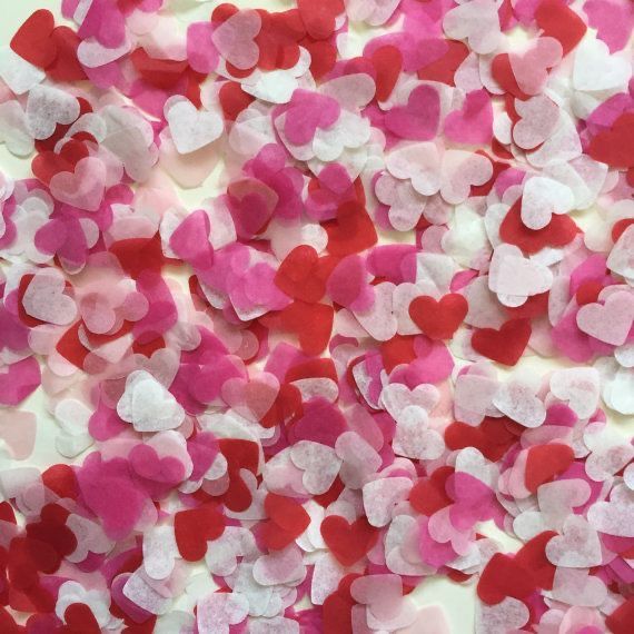 some pink and red hearts on a white surface