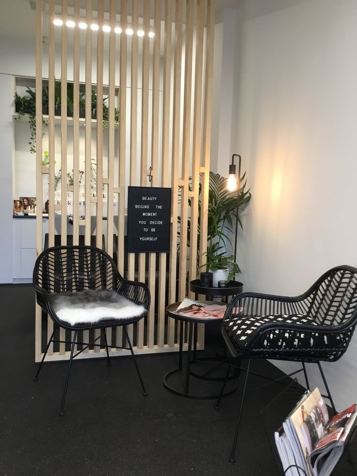 two black chairs sitting next to each other in front of a wooden wall with vertical slats