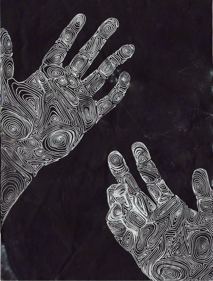 two hands reaching up to each other in front of a black and white drawing on paper