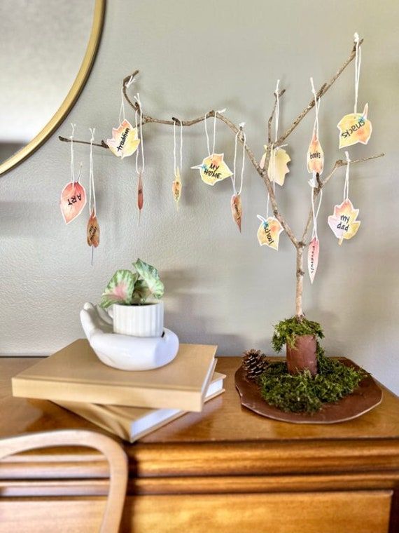 a small tree is decorated with cards and leaves