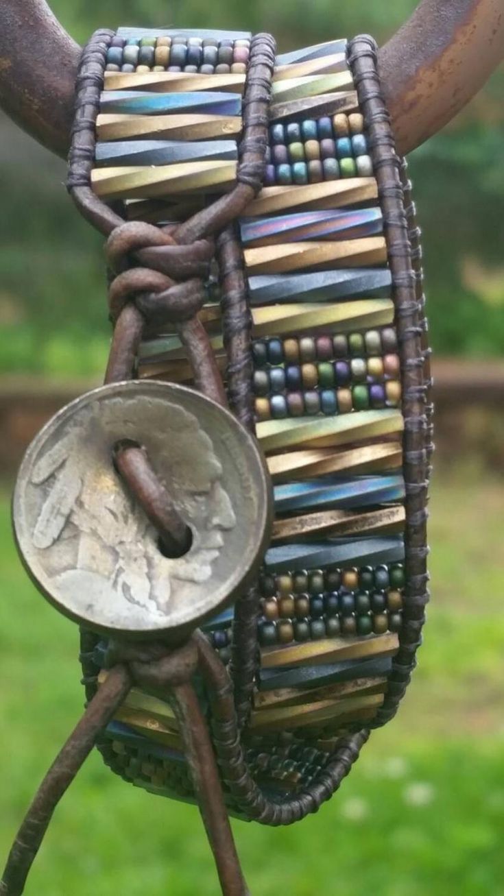 a close up of a cow's head with beads on it and a coin in its mouth