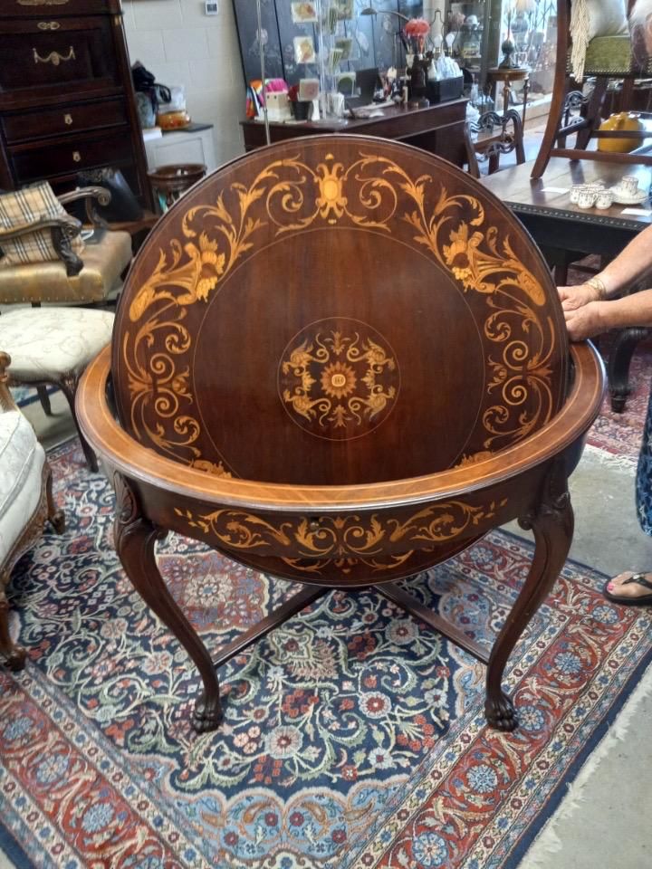 an ornately decorated table on top of a rug in a room filled with furniture