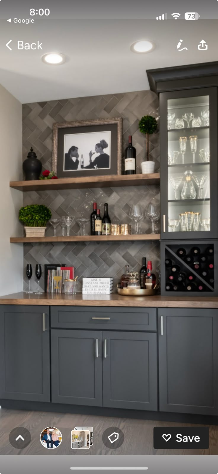 a kitchen with grey cabinets and shelves filled with wine glasses