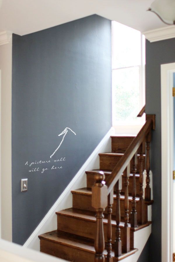 a stair case painted with white chalk on the wall next to a wooden banister