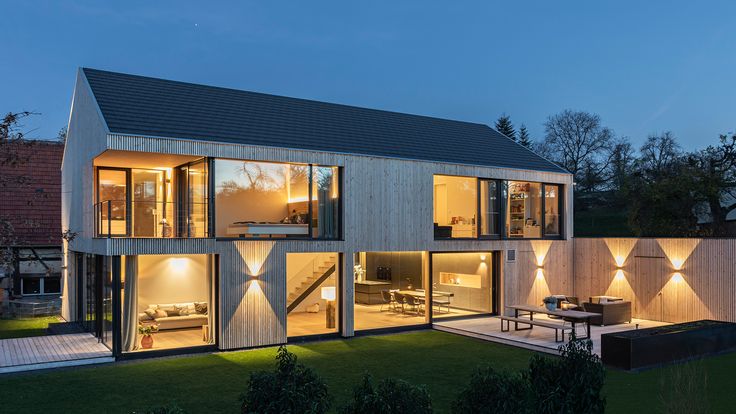 a modern house is lit up at night with outdoor lighting on the outside and inside