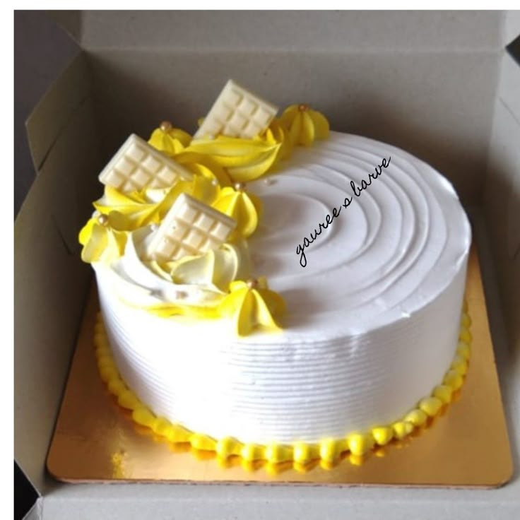 a white cake with yellow icing in a box