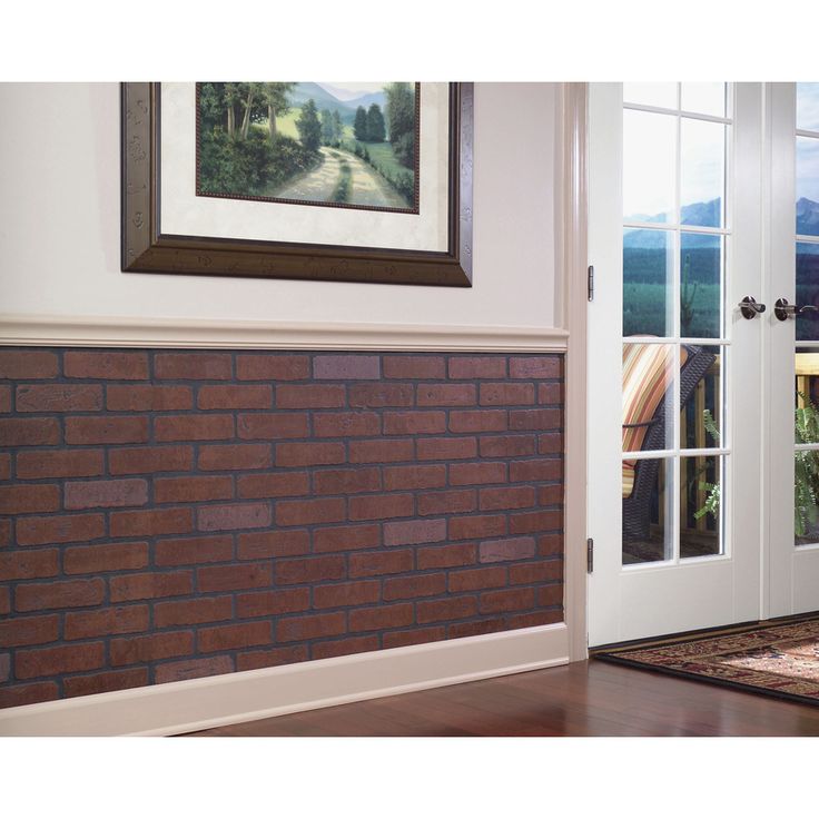 a brick wall in front of a white door with glass panes on the side